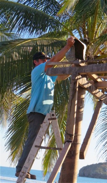 Lupe then used a small plastic container to pour the concrete down the tube.  every now and then he would tap the cardborad tube with a screwdriver in an effort to get the concrete to move down the tube.